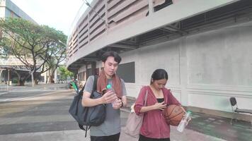 Men and women walk to relax after playing basketball in public areas, having fun and practicing together. video