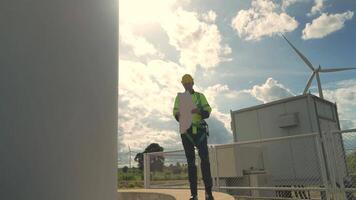 African engineer working in fieldwork. Worker inspect construction and machine around the project site. Wind turbine electrical of clean resource energy and environment sustainable. video