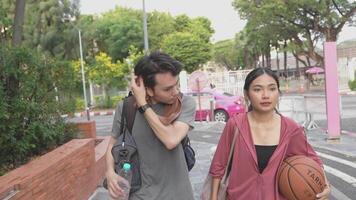 Men and women walk to relax after playing basketball in public areas, having fun and practicing together. video