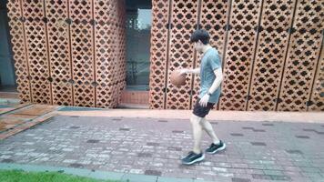 A man plays basketball alone in a public area, having fun and practicing at the same time. video