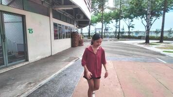 A woman plays basketball alone in a public area, having fun and practicing at the same time. video