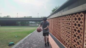 A man plays basketball alone in a public area, having fun and practicing at the same time. video