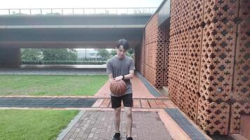 A man plays basketball alone in a public area, having fun and practicing at the same time. video