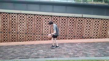 A man plays basketball alone in a public area, having fun and practicing at the same time. video