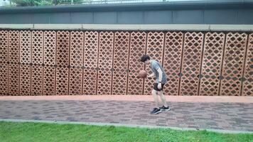 A man plays basketball alone in a public area, having fun and practicing at the same time. video