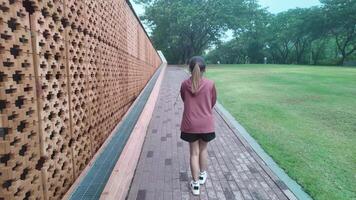A woman plays basketball alone in a public area, having fun and practicing at the same time. video