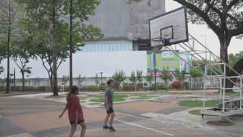 Men and women play basketball alone in public areas for fun and practice at the same time. video