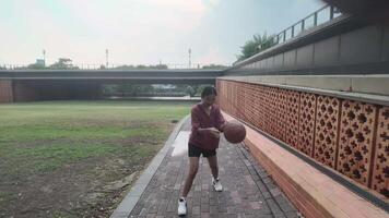 A woman plays basketball alone in a public area, having fun and practicing at the same time. video