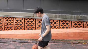 A man plays basketball alone in a public area, having fun and practicing at the same time. video