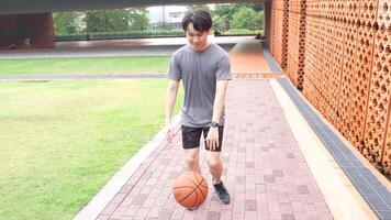 A man plays basketball alone in a public area, having fun and practicing at the same time. video
