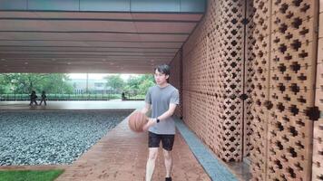 A man plays basketball alone in a public area, having fun and practicing at the same time. video