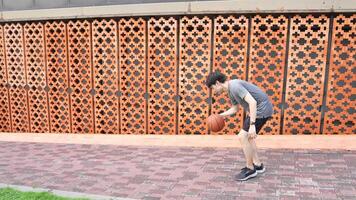 A man plays basketball alone in a public area, having fun and practicing at the same time. video