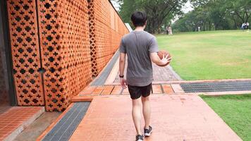 A man plays basketball alone in a public area, having fun and practicing at the same time. video