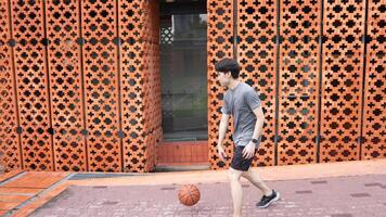 A man plays basketball alone in a public area, having fun and practicing at the same time. video