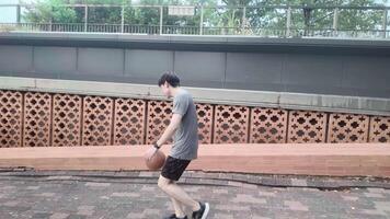 A man plays basketball alone in a public area, having fun and practicing at the same time. video