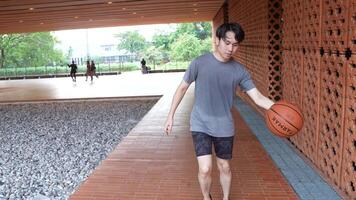 A man plays basketball alone in a public area, having fun and practicing at the same time. video