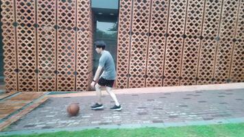 A man plays basketball alone in a public area, having fun and practicing at the same time. video