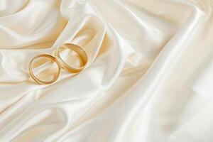 Elegant Wedding Bands Resting on a Silky White Fabric Surface photo