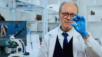 Mature man lab technician looking at virus sample in modern equipped laboratory. Scientist working with various bacteria tissue and blood tests, concept of pharmaceutical research for antibiotics photo