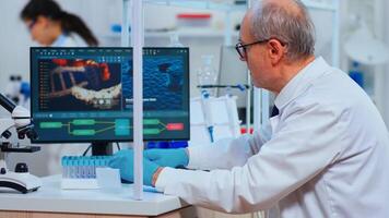 Senior man chemist examinining drug discovery using test tube in modern equipped laboratory. Multiethnic doctors examining vaccine evolution using high tech researching diagnosis against covid19 virus photo
