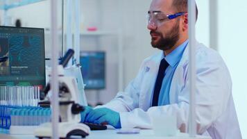 Biochemist checking manifestations of virus writing on computer with special software in chemistry laboratory. Group of doctors examining vaccine evolution using high tech researching diagnosis photo