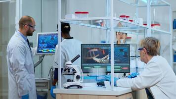 Multiethnic team working to develop a new vaccine in modern equipped laboratory. Diverse group of biochemistry scientists examining virus evolution using high tech for researching treatment photo