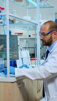Multiethnic team of scientist working in medical laboratory, developing inovative drugs. Lab modernly equipped prepared for vaccine innovation using high tech, chemistry tools for scientific research, against virus development photo