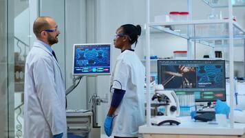 Team of multiethnic scientists working in laboratory analysing test trial vaccine checking drug data in pc. Diverse group of scientists examining virus evolution using high tech for research photo