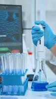 Close up of researcher testing liquid sample using micropipette for new treatment medical laboratory. Multiethnic team examining virus evolution using high tech for vaccine development against covid19 photo