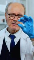 Mature man lab technician looking at virus sample in modern equipped laboratory. Scientist working with various bacteria tissue and blood tests, concept of pharmaceutical research for antibiotics photo