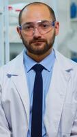 Tired doctor looking exhausted at camera in modern equipped lab. Multiethnic team examining virus evolution using high tech and chemistry tools for scientific research, vaccine development. photo