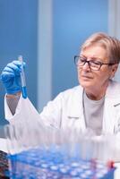 Senior doctor discovering genetic infection and analysing a test tube for medical expertise. Pharmaceutical scientist in research laboratory work with professional technology equipment for healdcare development photo