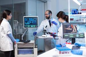 Scientists working In laboratory discovering genetic infection because of rare disease. Chemists in pharmaceutical lab examining sample for medical experiment with technology for medicine industry. photo