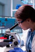 Close up of chemical technician microbiology analysing sample on microscope, modern technology. Modern laboratory with research equipment for virus study and vaccine science development. photo