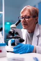 Experienced scientist engineering healthcare blood sample using microscope. Laboratory for scientific research with professional equipment for virus study and diagnosis biotechnolog development. photo