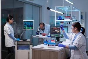 Professional doctor scientist looking in computer analysing DNA image scan. Chemists in pharmaceutical laboratory examining sample for medical experiment with technology for medicine industry. photo