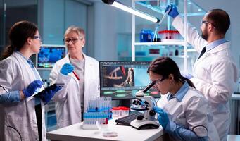 Group of researcher in healthcare laboratory study virus to discover vaccineResearch chemists working in lab with high tech analyzing blood and genetic material samples discovery, photo