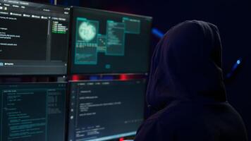 Dangerous man hacking, stealing credit card numbers and infiltrating banking systems, handheld camera shot. Close up of hacker running code in apartment on PC monitors, camera B photo