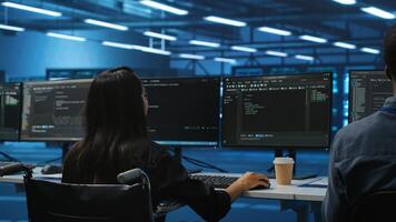Woman with impairment next to diverse coworkers in data center coding on computer. Wheelchair user and multiethnic team working together, in inclusive and diverse workspace, doing programming photo