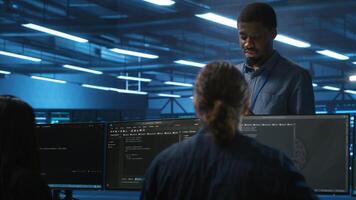 Supervisor in server hub workplace managing diverse team of developers looking for equipment software misconfigurations. Manager coordinating professionals mending data center bugs photo