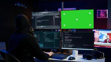 Dangerous man hacking using green screen PC, stealing credit card numbers and infiltrating banking systems. Hacker running code in apartment on mockup computer display, camera B photo