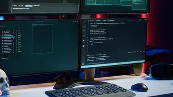 Close up shot of dangerous hacking code running on high tech computer system monitors. Programming scripts shown on PC displays in empty criminal hideout used by hackers to commit illegal activities photo