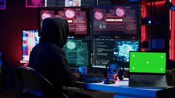 Hacker doing computer sabotage using trojan ransomware on green screen laptop. Cybercriminal uses mockup device to demand ransom money from victims in exchange for access to their data, camera A photo