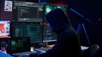Hacker arriving in hidden underground shelter, prepared to launch DDoS attack on websites. Cybercriminal in apartment starting work on script that can crash businesses servers, camera B photo