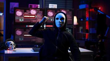 Dissident social justice crusader doing online activism, wearing anonymous masks and filming in underground bunker, blackmailing government after stealing secret military documents, camera B photo