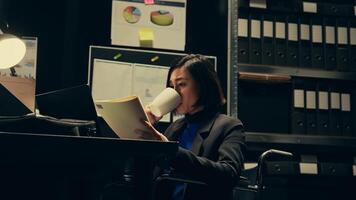Private agent studying criminal files and archived folders in incident room, working on legal investigation to build suspects profile. Wheelchair user reading statements and reports. Camera B. photo