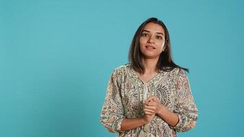 Portrait of jealous indian woman mockingly clapping hands, isolated over studio background. Annoyed person rolling eyes and applauding in jest, doing fake cheering, camera A photo