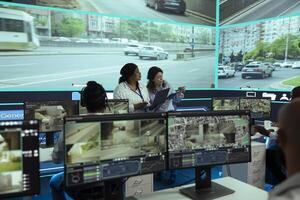 Employees team monitoring urban traffic with radar sensors on a big screen, using real time surveillance footage to ensure public safety. Agency utilizing CCTV satellite system on the streets. photo