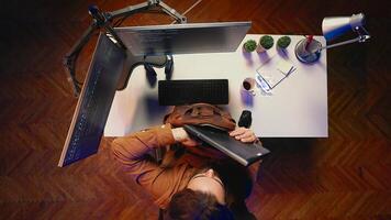 Top down view of software programmer finishing remote job shift, packing backpack, leaving office after finishing project. Aerial shot of IT admin putting laptop in bag, sitting up from desk chair photo