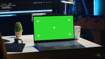 Green screen laptop in home office used for developing software applications. Mockup notebook used by teleworking IT specialist for programming, camera A close up panning shot photo